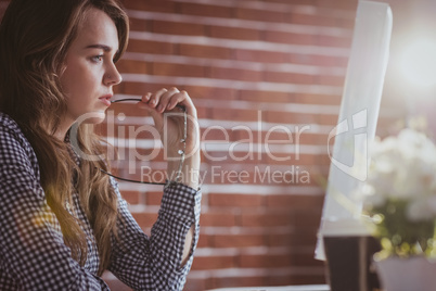 Thoughtful hipster businesswoman watching computer