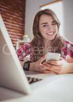 Smiling hipster businesswoman using her phone