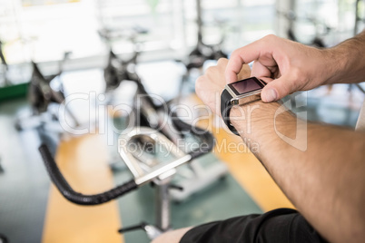 Close up of man using smartwatch on exercise bike