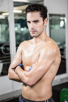Serious shirtless man with arms crossed