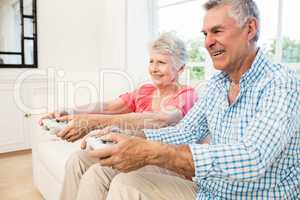 Happy senior couple playing video games
