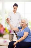 Physiotherapist taking care of sick elderly patient