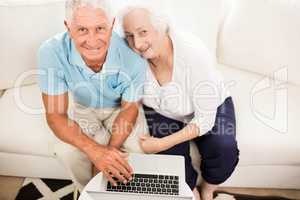 Smiling senior couple using laptop