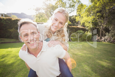 Husband giving piggy back to wife