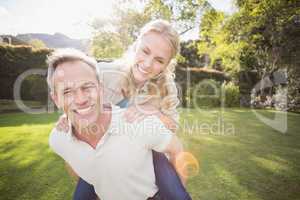 Husband giving piggy back to wife