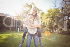 Husband giving piggy back to wife