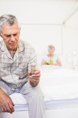 Suffering senior man taking pills