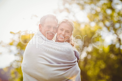 Cute couple hugging with a blanket around