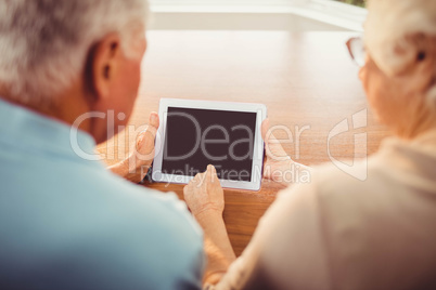 Rear view of senior couple using tablet