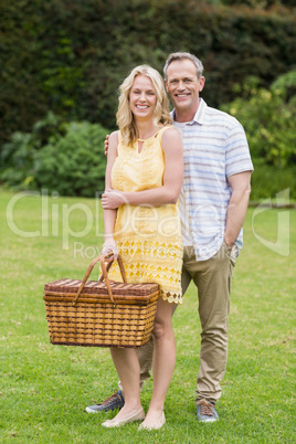 Happy couple holding picnic basket