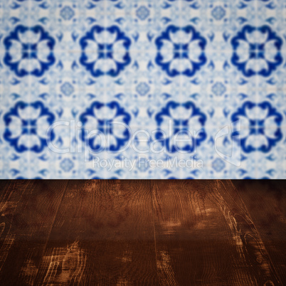 Wood table top and blur vintage ceramic tile pattern wall