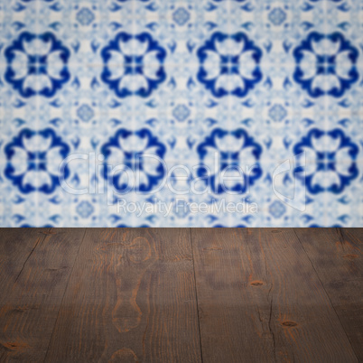 Wood table top and blur vintage ceramic tile pattern wall