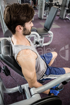 Focused man using weights machine for arms