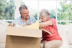 Senior couple opening big box