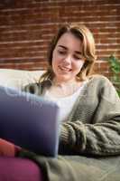 Pretty woman using tablet lying on the couch