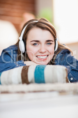 Pretty woman listening music lying on the floor