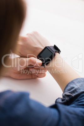 Casual businesswoman using her smart watch