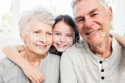 Portrait of smiling grandparents and granddaughter