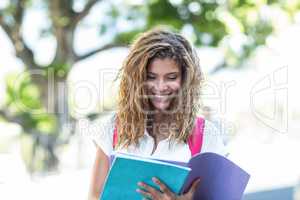 Hip woman reading notes on notebook