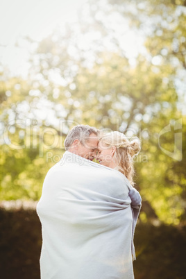 Cute couple hugging with a blanket around