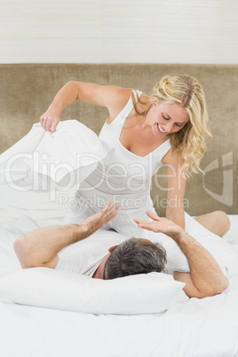 Cute couple playing pillow fight