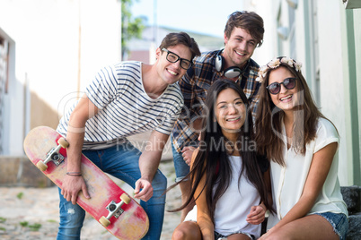 Hip friends sitting on steps and smiling at the camera