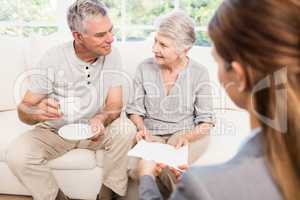 Businesswoman showing documents to senior couple