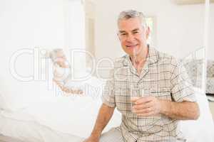 Peaceful senior man holding glass of water