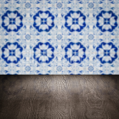 Wood table top and blur vintage ceramic tile pattern wall