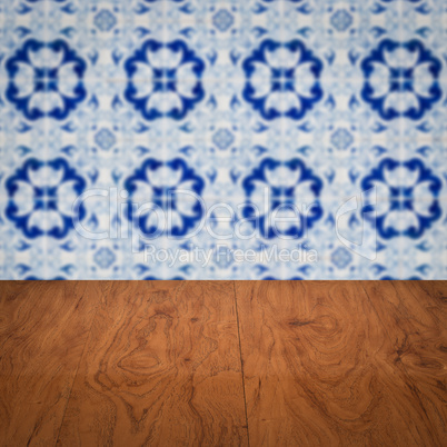 Wood table top and blur vintage ceramic tile pattern wall