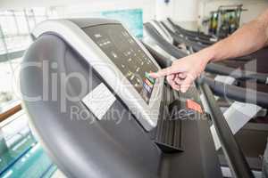 mans hand setting treadmill