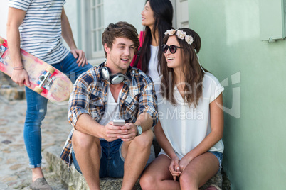 Hip friends talking and sitting on steps