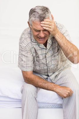 Suffering senior man touching his forehead