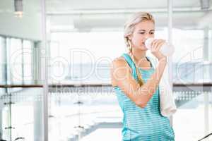 Smiling blonde drinking water