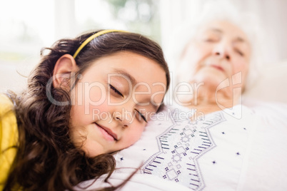 Relaxed granddaughter and grandmother napping