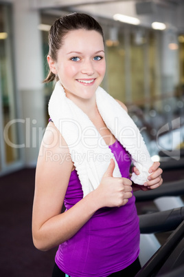 Smiling fit woman with towel around her neck