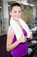 Smiling fit woman with towel around her neck