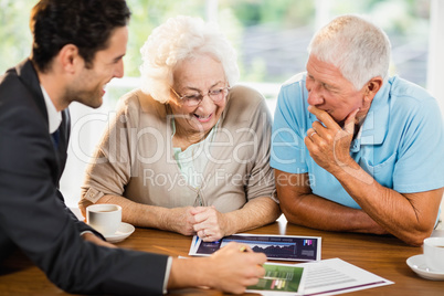 Businessman showing sheets to senior couple