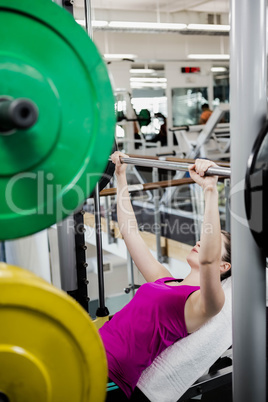 Fit woman lifting the barbell bench press