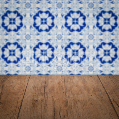 Wood table top and blur vintage ceramic tile pattern wall