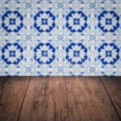Wood table top and blur vintage ceramic tile pattern wall