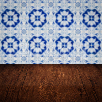 Wood table top and blur vintage ceramic tile pattern wall