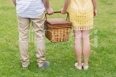 Happy couple holding picnic basket