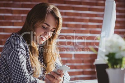 Young hipster businesswoman using her phone