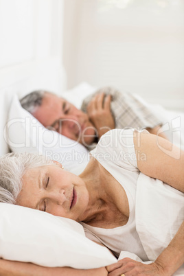 Senior couple sleeping in bed