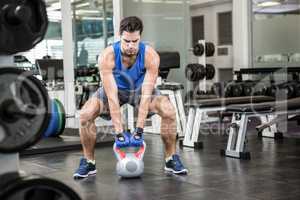 Handsome man lifting kettlebell