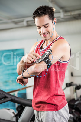 Smiling man on treadmill using smartphone