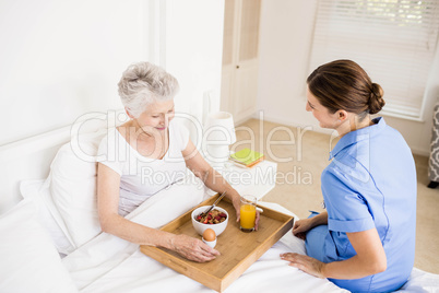 Nurse taking care of suffering senior patient