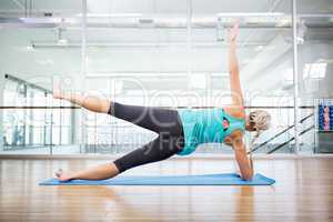 Fit blonde doing exercise on mat