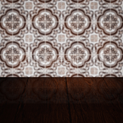 Wood table top and blur vintage ceramic tile pattern wall